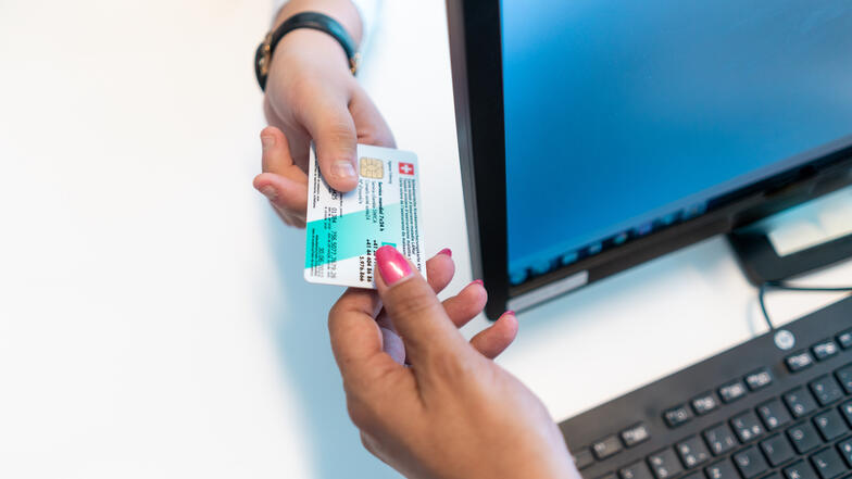 Photo d'une formalité d'admission: gros plan sur une main qui tient une carte d'assurance 