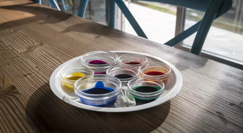 Une table, des chaises et des pots de peinture: tout est prêt pour l'art-thérapie