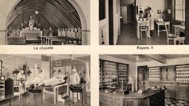 Postkarte mit Schwarzweissfotos von einigen Abteilungen des Kantonsspitals Freiburg: Die Kapelle, ein Raum mit Tisch und Stühlen sowie einem Röntgengerät, ein Elektrotherapieraum mit zwei Patienten in Betten und die Pharmazie mit Schränken voller Fläschchen. 